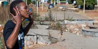 Community activist Nozipho Moremongwe next to the largest sinkhole in Khutsong, Carltonville on 15 May 2024. It has destroyed a main road and threatens surrounding homes. (Photo: Chris Collingridge)