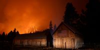 SOUTH LAKE TAHOE, CALIFORNIA - AUGUST 30: The Caldor Fire burns in the hills above homes on August 30, 2021 near South Lake Tahoe, California. The fire continues to advance towards South Lake Tahoe and a red flag warning has been issued as high winds begin to kick up. The fire has burned more than 175,000 acres, destroyed hundreds of homes and is currently 14 percent contained. (Photo by Justin Sullivan/Getty Images)