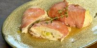 Bacon-wrapped chicken parcels stuffed with cheese and spring onion