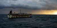 A Chinese squid jigger transiting across dark waters and ominous skies near the Falkland Islands in February 2022. (Photo: Ed Ou//The Outlaw Ocean Project)