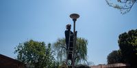 A contractor procured from the City of Joburg’s Human Settlements Department fixes streetlights on the premises of the Eeufees Oord Old Age Home on the day of the Joburg office of the Ombudsman’s stakeholder engagement, 26 August 2022. (Photo: Julia Evans)
