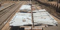 Two men on the roof of a building at the Klipspruit train station as they prepare to strip it of metal roofing. (Photo: Shiraaz Mohamed)