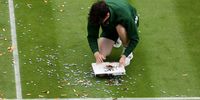 A member of staff helps clear orange confetti and a jigsaw puzzle on court 18 after a Just Stop Oil protest. (Photo by Julian Finney/Getty Images)