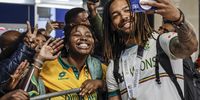 Proteas player Tony De Zorzi (right) takes a selfie with a supporter upon arriving with the rest of the team at OR Tambo International Airport in Kempton Park on 18 June 2025. (Photo: Phill Magakoe / AFP)