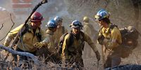 Firefighters from the California Conservation Corps work to contain the Eaton Fire in Altadena, California, on 13 January. (Photo: Benjamin Fanjoy / Bloomberg via Getty Images)