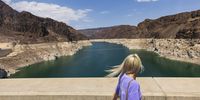 epa09619033 A person looks at the white ring of mineralized stone indicating the drop in water levels near the Hoover Dam at Lake Mead National Recreation Area in Boulder City, Nevada, USA, 19 June 2021. Lake Mead, the United States' largest reservoir, which was formed by the construction of the Hoover Dam along the Colorado River east of Las Vegas, Nevada on the Nevada/Arizona border, is at the lowest levels ever recorded since being built as a result of drought, high temperatures and water usage.  EPA-EFE/JUSTIN LANE