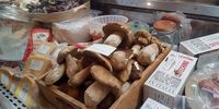 Fresh porcini mushrooms take pride of place in the deli counter along with purple hued artichokes, and Italian cotechino traditionally served with lentils for good fortune at New Year. (Photo: Kit Heathcock)<br>