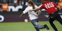A fan runs onto the pitch as security follows during the second half of the CONCACAF Gold Cup semifinal soccer match between Mexico and Jamaica in Las Vegas, Nevada, USA, 12 July 2023. EPA-EFE/CAROLINE BREHMAN