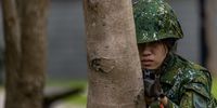 A female military reservist holds a gun during a Taiwanese military reservist training exercise on May 09, 2023 in Taoyuan, Taiwan. Taiwan's military is recalling the first group of female veterans to undergo reservist training. (Photo by Annabelle Chih/Getty Images)