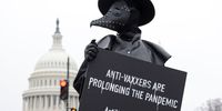 WASHINGTON, DC - MARCH 25:  A man holds a sign and dresses as a plague doctor to encourage people to be vaccinated and prevent prolonging the COVID-19 pandemic March 25, 2021 on Capitol Hill in Washington, DC. The Subcommittee on Communications and Technology and the Subcommittee on Consumer Protection and Commerce of the Committee on Energy and Commerce of House Energy &amp; Commerce Committee held a joint hearing today on "Disinformation Nation: Social Media's Role in Promoting Extremism and Misinformation." (Photo by Alex Wong/Getty Images)