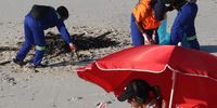 "It ends with us. The buck stops here. Workers cleaning Muizenberg beach." Image: Peter Reber