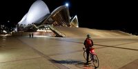 SYDNEY, AUSTRALIA - JUNE 26: A cyclist looks on at an empty Sydney Opera House which is closed due to Covid-19 on June 26, 2021 in Sydney, Australia. Lockdown restrictions have come into effect across Great Sydney, the Blue Mountains, the Central Coast and Wollongong as NSW health authorities work to contain a growing COVID-19 cluster. From 6pm on Saturday, all residents in areas subject to stay-at-home orders are only permitted to leave their homes for essential reasons, including purchasing essential goods, accessing or providing care/healthcare, work, education and exercise. The restrictions will remain in place until midnight on Friday 9 July. (Photo by Brendon Thorne/Getty Images)
