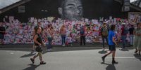 MANCHESTER, ENGLAND - JULY 14: People look at the newly repaired mural of England footballer Marcus Rashford by the artist known as AKSE_P19, which is displayed on the wall of a cafe on Copson Street, Withington, on July 14, 2021 in Manchester, England. Rashford and other Black players on England's national football team have been the target of racist abuse, largely on social media, after the team's loss to Italy in the UEFA European Football Championship last night. England manager Gareth Southgate, Prime Minister Boris Johnson, and the Football Association have issued statements condemning the abuse.  (Photo by Christopher Furlong/Getty Images)
