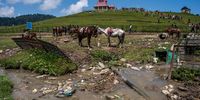 Non-biodegradable waste floats in on a stream as tourists enjoy in the Meadow of flowers on May 15, 2023 in Gulmarg, west of Srinagar, Indian administered Kashmir, India. Gulmarg, also known as the "Meadow of Flowers," is home to the world's highest golf course and a gondola lift that reaches elevations exceeding 4,000 meters. Ski enthusiasts flock to this mountainous region during the winter months to take advantage of the powdery snow. In the summer, however, the resort is flooded with tourists in search of clean, refreshing air due to India's soaring temperatures. Many of these visitors leave behind a significant amount of waste, causing severe ecological threats and endangering villagers who rely on the glacial waters. The accumulation of trash poses a grave danger to the delicate alpine ecology, as well as to the communities that depend on the glacier-fed streams for their water supply. There are no restrictions on bringing food and water up the mountain, despite signs along the road reminding people that plastic is prohibited. Environmental activists caution that all the waste generated in Gulmarg and its surrounding areas is being indiscriminately discarded in the mountains. (Photo by Yawar Nazir/Getty Images)
