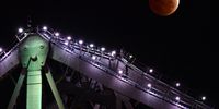 epa09591145 The Moon is seen above Brisbane's Story Bridge as the earth's shadow covers the moon during a partial lunar eclipse over Brisbane,  Australia, 19 November 2021. The moon will pass almost totally into the earth's shadow during the partial lunar eclipse, sometimes referred to as a 'blood moon' due to the reddish tinge.  EPA-EFE/DARREN ENGLAND AUSTRALIA AND NEW ZEALAND OUT