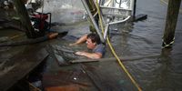 A shrimper works to salvage a shrimp boat that was partially submerged by Hurricane Ida in Golden Meadow, Louisiana, U.S., on Tuesday, Aug. 31, 2021. More than a million customers in New Orleans and beyond face days or even weeks without electricity during the summer heat after Hurricane Ida devastated the power infrastructure. Photographer: Luke Sharrett/Bloomberg via Getty Images