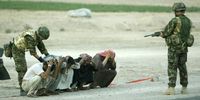 British soldiers stop and search Iraqis at a checkpoint near Basra, 2003. (Photo: EPA/Pool, Dan Chung)