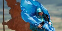 epa09247205 A pilgrim wearing a raincoat fights against the wind to take a photograph from the top of El Perdon mount on a windy day in Pamplona, Spain, 04 June 2021.  EPA-EFE/Jesus Diges