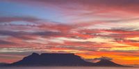 Golden hues over Table Mountain, where the ocean meets the sky in a fiery farewell. Cape Town, bathed in the colours of dusk. Photographer: Lucina De Bruin