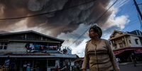 KARO, NORTH SUMATRA, INDONESIA - JUNE 19:  A woman looks skyward as Mount Sinabung spews pyroclastic smoke, seen from Simpang Empat village on June 19, 2015 in Karo District, North Sumatra, Indonesia. According to The National Disaster Mitigation Agency, more than 10,000 villagers have fled their homes since the authorities raised the alert status of Mount Sinabung erupting to the highest level. (Photo by Ulet Ifansasti/Getty Images)