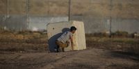 A Palestinian youth takes cover behind a concrete block during clashes with Israeli troops on the eastern border of the Gaza Strip, 18 September 2023. According to the Palestinian Ministry of Health, at least five Palestinians were wounded during the clashes near the border between Israel and the Gaza Strip.  EPA-EFE/MOHAMMED SABER