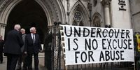 Campaigners attach a banner to the entrance of the High Court on 28 July 2015 in London, England. A public inquiry had opened into the use of undercover police in England and Wales. (Photo: Peter Macdiarmid / Getty Images)