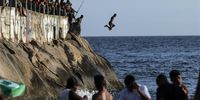 epaselect epa10424083 A man jumps into the sea at Leme beach in Rio de Janeiro, Brazil, 22 January 2023.  EPA-EFE/Antonio Lacerda