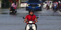 A man wades through a flooded area with his motorcycle in Tumpat, state of Kelantan, Malaysia, Malaysia, 02 December 2024. According to the National Disaster Control Center (NDCC), around 130,000 people have been displaced due to the floods nationwide across nine states while five deaths have been recorded.  EPA-EFE/FAZRY ISMAIL