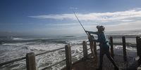 A fisherman casts on a pier on the Durban beach front. (Photo: Rogan Ward)
