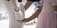 A child holds the hand of a Leju Robotics  humanoid robot at the World AI Conference in Shanghai, China, on 7 July 2023. (Photo: Qilai Shen / Bloomberg via Getty Images)
