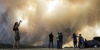 A girl takes a selfie as other residents watch a wildfire near the village of Pournari, in Dervenochoria, northwest of Attica region, Greece, 18 July 2023. There are still active fronts in Dervenochoria, in spite of the intervention of water-bombing aircraft according to government sources. A message was sent to people in Attica and the wider area around Dervenochoria via the emergency number 112, instructing them to stay indoors and close their doors and windows due to the ongoing wildfire. EPA-EFE/KOSTAS TSIRONIS