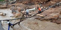 People trying to cross a river in Ntuzuma where a bridge was washed away. (Photo: Mandla Langa)