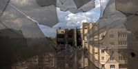 A look through broken window glass shows residential buildings damaged during Russian attacks in Irpin, Ukraine, 16 June 2022. EPA-EFE/ROMAN PILIPEY