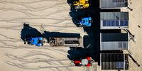 An aerial view shows trucks carrying beach houses as preparations for a summer season started on the beach of IJmuiden, The Netherlands, 03 April 2023.  EPA-EFE/REMKO DE WAAL