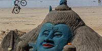 epa09067526 A boy perform stunts with his bicycle near a sand sculpture of Hindu god Lord Shiva, made by Indian sand artist Laxmi Gaud for visitors and tourists to see on the occasion of Maha Shivaratri at the Juhu beach in Mumbai, India, 11 March 2021. The Maha Shivaratri festival is celebrated by Hindus in honor of Lord Shiva with ritual bathing of Shivalingams and prayers. According to one of the most popular legends Shivaratri is the wedding day of Lord Shiva and Parvati.  EPA-EFE/DIVYAKANT SOLANKI