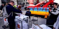  A man casts a ballot into a shredder in a mock version of Russian elections as an effigy of Russian President Vladimir Putin bathing in the blood of Ukraine stands behind outside the Russian Embassy during Russian elections on March 17, 2024 in Berlin, Germany. Presidential elections in Russia, which are taking place without any meaningful opposition candidates allowed, will conclude today with President Vladimir Putin all but certain to be reelected. (Photo by Sean Gallup/Getty Images)