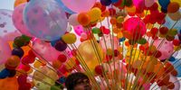 DELHI, INDIA - NOVEMBER 10: A balloon seller waits for customers who are gathered along the banks of River Yamuna amid toxic foam caused by pollution on the occasion of  Chhat puja  on November 10, 2021 in Delhi, India. (Photo by Anindito Mukherjee/Getty Images)