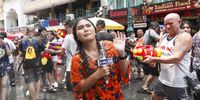 A TV reporter reacts during a water gun battle as part of the annual Songkran festival, also known as water festival, the traditional Thai New Year celebrations, at the tourist spot of Khao San Road in Bangkok, Thailand, 13 April 2023. Thailand celebrates its first water-splashing Songkran festival following a three-year pause due to the COVID-19 pandemic. Songkran is celebrated with splashing water and putting powder on each other's faces as a symbolic sign of cleansing and washing away the sins from the old year.  EPA-EFE/RUNGROJ YONGRIT