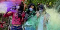 epa08280904 Indian girls apply colored powder on each other as they wear protective masks in precautionary measures against Coronavirus during Holi festival celebrations in Bhopal, 09 March 2020. Holi festival is an ancient Hindu festival the annual event marks the triumph of good over evil, it also honors fertility and love, and celebrates colors and spring.  EPA-EFE/SANJEEV GUPTA