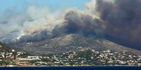 Thick smoke rises during a wildfire in Lagonisi area, Attica, Greece, 17 July 2023. Firefighting forces are battling a blaze that broke out in the Kouvaras area in Attica, while a warning was sent via the emergency number 112 to evacuate several settlements in southeast Attica. A force of 55 firefighters and 20 fire engines, two units on foot and 31 Romanian firefighters with five water tankers have been deployed to put out the fire, assisted by six fire-fighting aircraft and four helicopters from the air. EPA-EFE/ORESTIS PANAGIOTOU