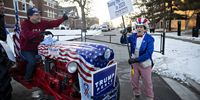 A demonstrator dressed as Uncle Sam, right, recites a poem denouncing U.S. President Donald Trump as a supporter of President Trump looks on from the seat of his tractor ahead of the Democratic presidential debate in Des Moines, Iowa, U.S., on Tuesday, Jan. 14, 2020. A winnowed slate of six candidates will gather for a televised event that will likely expose the growing rifts between and within the Democratic Party's moderate and progressive flanks. Photographer: Daniel Acker/Bloomberg via Getty Images