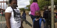 Mother Iminathi Gwabeni and son Nolutho Gwabeni stand outside the gate of Ikaya Primary School in Kayamandi. (Photo: Rebecca Pitt)