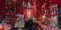 A vendor wearing a protective mask waits for customers at a decorations store at the Yuyuan Bazaar ahead of Lunar New Year in Shanghai, China, on Wednesday, Jan. 27, 2021. The Lunar New Year begins on Feb. 12, and marks the start of the Year of the Ox. Photographer: Qilai Shen/Bloomberg via Getty Images