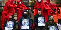 GLASGOW, SCOTLAND - NOVEMBER 08: Red Rebels join protesters from Extinction Rebellion for a die in outside the offices of American asset management firm Mercer on November 08, 2021 in Glasgow, Scotland. As World Leaders meet to discuss climate change at the COP26 Summit, many climate action groups have taken to the streets to protest for real progress to be made by governments to reduce carbon emissions, clean up the oceans, reduce fossil fuel use and other issues relating to global heating. (Photo by Jeff J Mitchell/Getty Images)