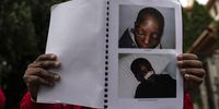 Chairman of the Movement for Democratic Change Alliance (MDC) Trust Ndlovu holds up a poster of the alleged beatings to political prisoners.<br>Photo / Shiraaz Mohamed.