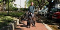 Professor Justin Jonas in 2022, standing where “inter-networking” in South Africa began, between the Struben Computing Centre and the Physics Department at Rhodes University, with dog Koda. Image: Chris Marais<br>