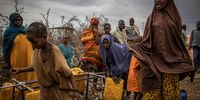 BAIDOA, SOMALIA - SEPTEMBER 3: People try to fill water bottles in a displacement camp for people impacted by drought on September 3, 2022 in Baidoa, Somalia. Extreme drought has destroyed crops and seen a hike in food prices, leaving 7 million people (out of a total population of 16 million) at risk of famine in Somalia. (Photo by Ed Ram/Getty Images)