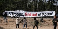 South Korean peace-activists hold a placard outside of the SK/US joint amphibious exercise area in Pohang, South Korea on March 29, 2023. South Korea and the United States are conducting a joint amphibious exercise called ‘Ssang Yong 2023 Exercise’ to strengthen the alliance’s combat readiness and improve interoperability, in Pohang, South Korea. ‘Ssang Yong’ is a joint command exercise designed to provide training for South Korea and US combined forces command in the various aspects of Reception, Staging, Onward, Movement and Integration of forces from bases outside of the USA. (Photo by Woohae Cho/Getty Images)