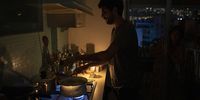 An NGO worker cooks pasta on a gas hob by candlelight during a power cut in Beirut, Lebanon, on 17 August 2021. Egypt agreed to supply natural-gas to Lebanon through Jordan and Syria as the Arab states seek to help end power shortages in their crisis-ridden neighbor. (Photo: Francesca Volpi/Bloomberg via Getty Images)