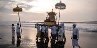 GIANYAR, BALI, INDONESIA - FEBRUARY 28: Balinese Hindus people carry Jempana, a sacred temple paraphernalia during Melasti Ritual prior to Nyepi Day on February 28, 2022 on a beach in Gianyar, Bali, Indonesia. Balinese Hindus dressed in predominantly white attire carried sacred effigies of gods and goddesses and ritual paraphernalia from their village temples to the beach to perform a purification ceremony called the Melasti ritual. Balinese Hindus believe the Melasti ritual is a must perform ahead of Nyepi Day, The Day of Silence, to cleanse the soul and nature, recharge the supernatural power of the temples sacred objects and cleanse the temple paraphernalia. The Nyepi Day is a national holiday in Indonesia and is a day for self-reflection and abstaining from distractions such as entertainment. (Photo by Agung Parameswara/Getty Images)